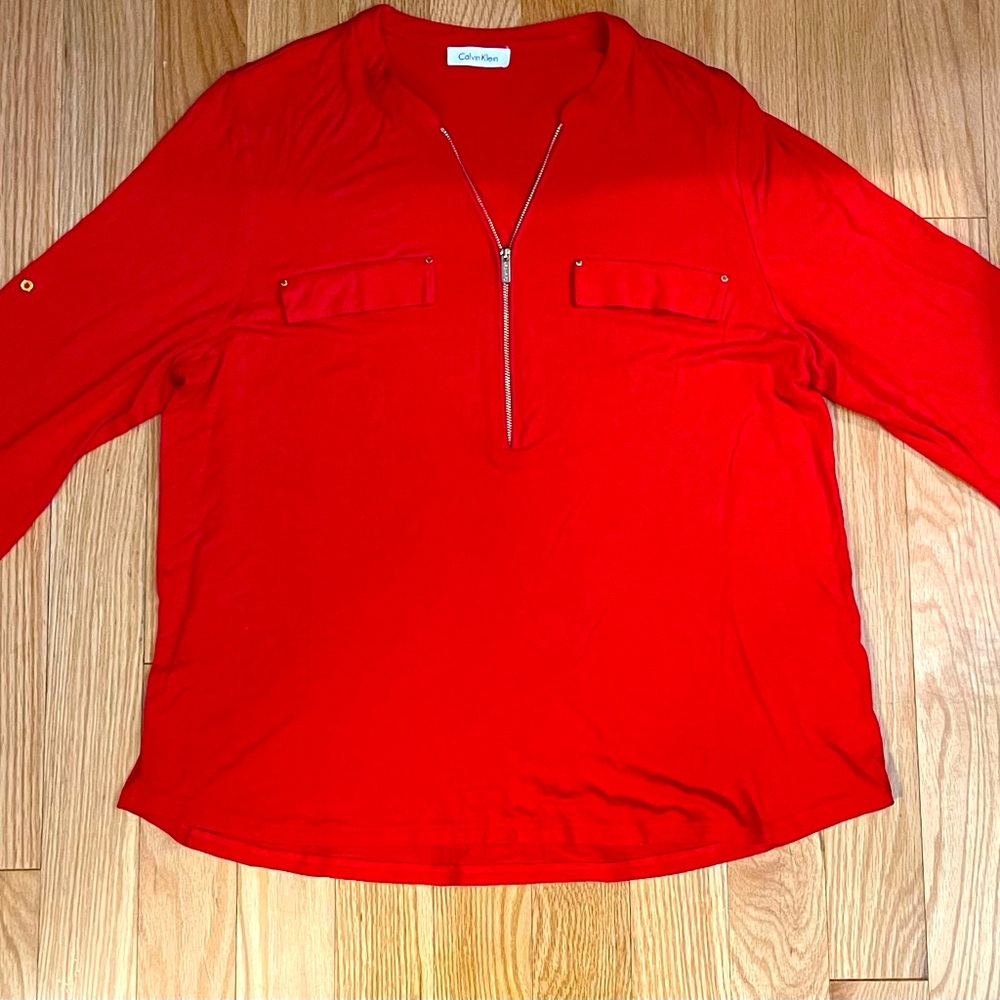 Women’s Calvin Klein, front zip red three-quarter sleeve blouse. Missing tags.